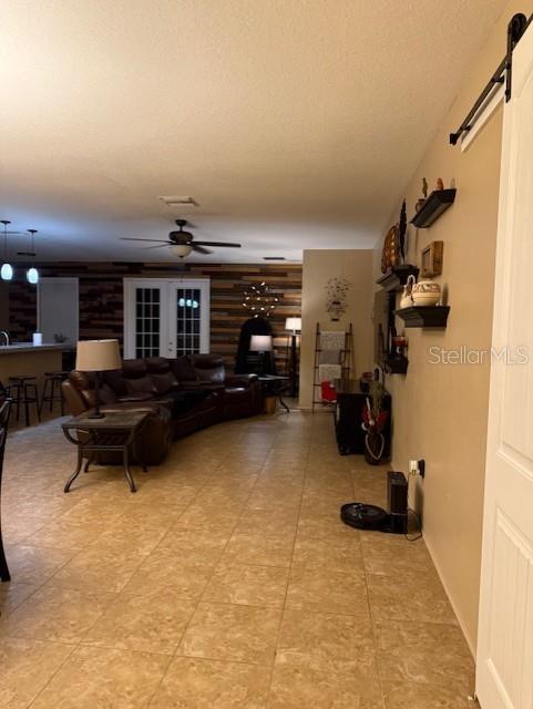 living room featuring ceiling fan and a barn door