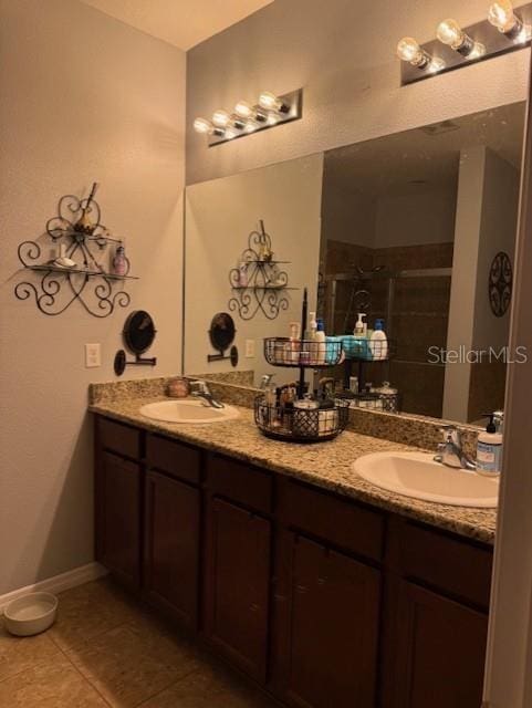 bathroom featuring an enclosed shower, vanity, and tile patterned flooring