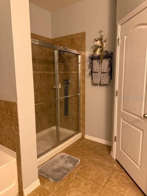 bathroom with tile patterned floors and shower with separate bathtub