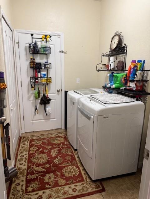 clothes washing area featuring light tile patterned floors and independent washer and dryer