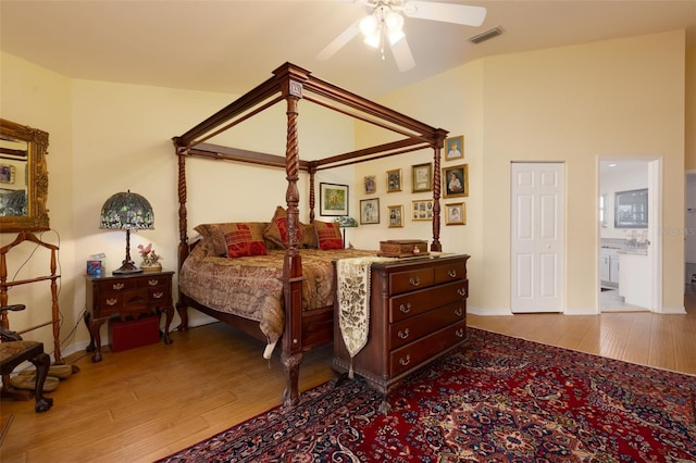 bedroom featuring ensuite bath, light hardwood / wood-style floors, and ceiling fan