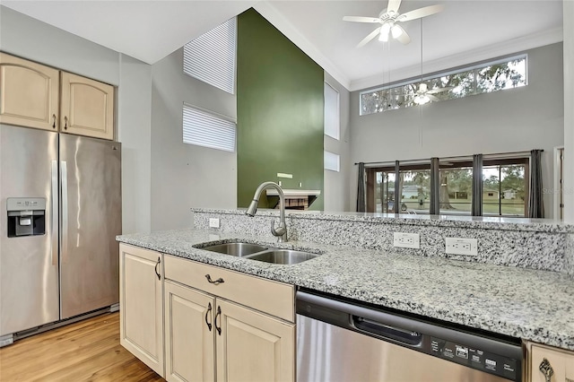 kitchen with light stone countertops, ceiling fan, appliances with stainless steel finishes, and sink