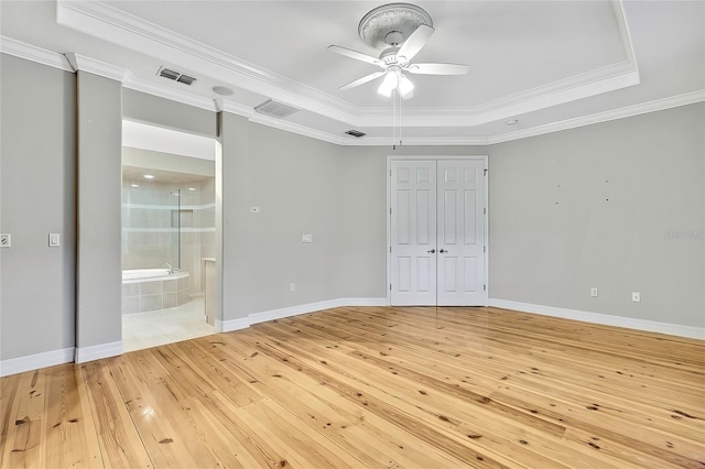 unfurnished bedroom with ceiling fan, a tray ceiling, and crown molding