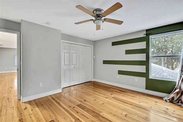 unfurnished bedroom with ceiling fan, hardwood / wood-style floors, and a closet