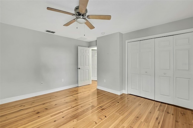 unfurnished bedroom with ceiling fan, light wood-type flooring, and a closet