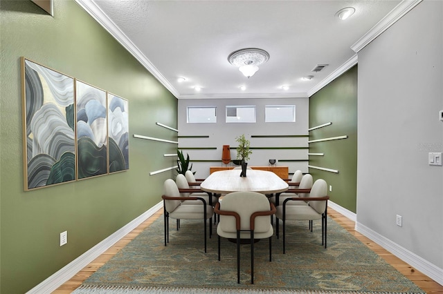 dining area with hardwood / wood-style flooring and ornamental molding