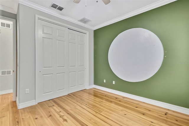 unfurnished bedroom featuring crown molding, wood-type flooring, a closet, and ceiling fan