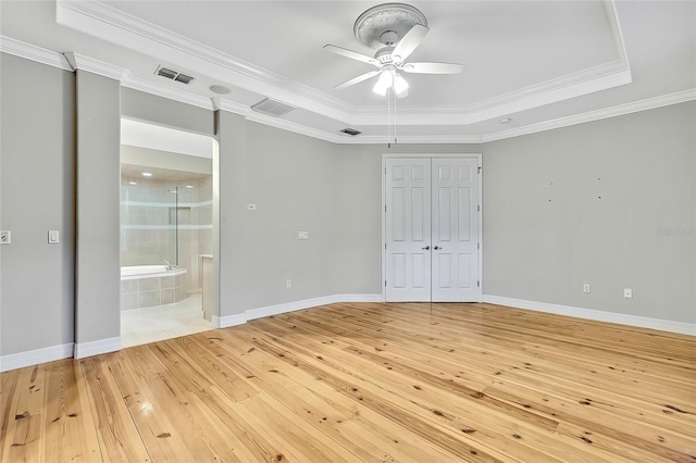 unfurnished bedroom with crown molding, ceiling fan, and a raised ceiling
