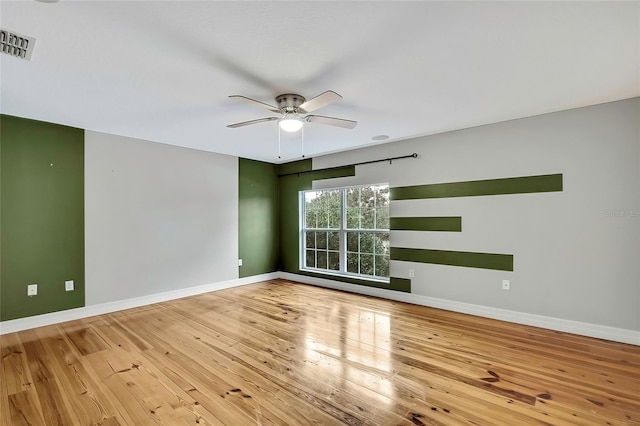 spare room featuring wood-type flooring and ceiling fan