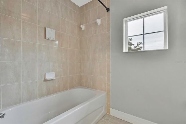bathroom with tiled shower / bath combo and tile patterned floors