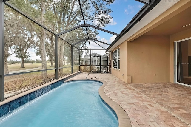 view of swimming pool featuring glass enclosure, pool water feature, and a patio