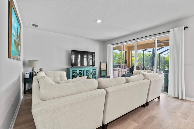 living room with wood-type flooring and a textured ceiling