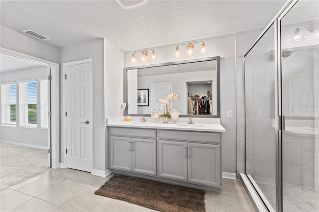 bathroom featuring a textured ceiling, walk in shower, and vanity