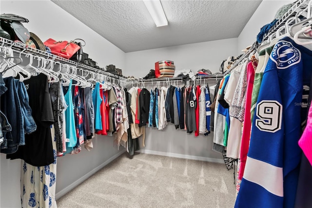 walk in closet featuring carpet flooring