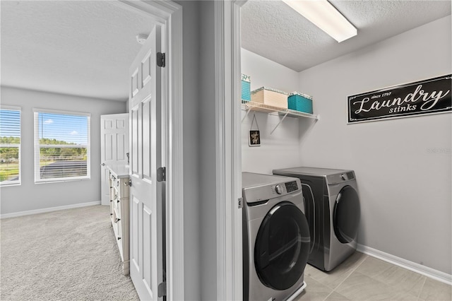 washroom featuring light colored carpet, independent washer and dryer, and a textured ceiling