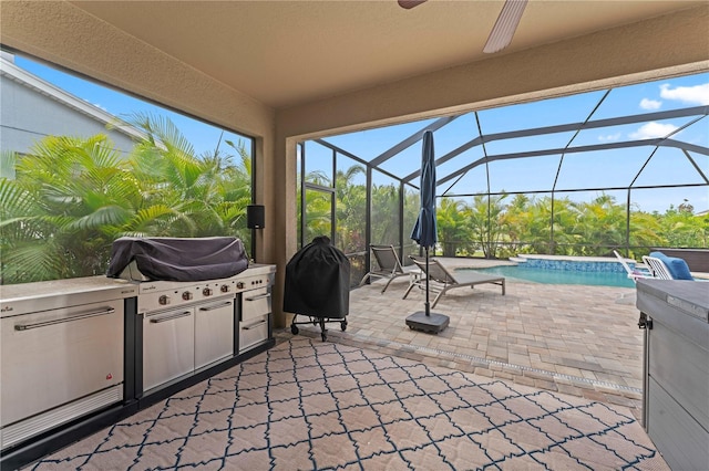 view of patio with ceiling fan, an outdoor kitchen, and glass enclosure