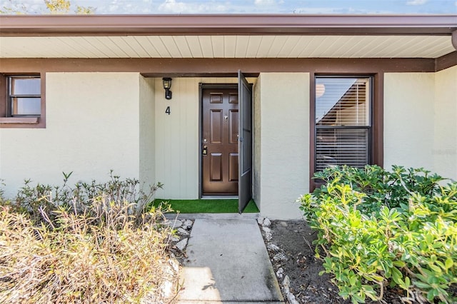 entrance to property featuring stucco siding