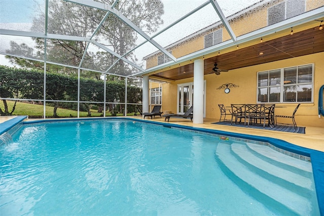 view of swimming pool with ceiling fan, a lanai, pool water feature, and a patio