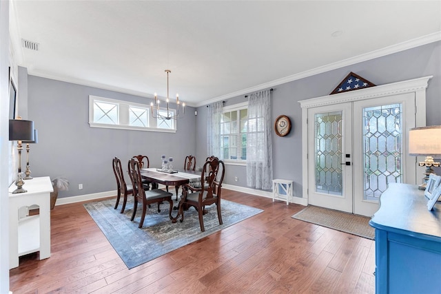 dining room with french doors, a chandelier, dark hardwood / wood-style flooring, and ornamental molding