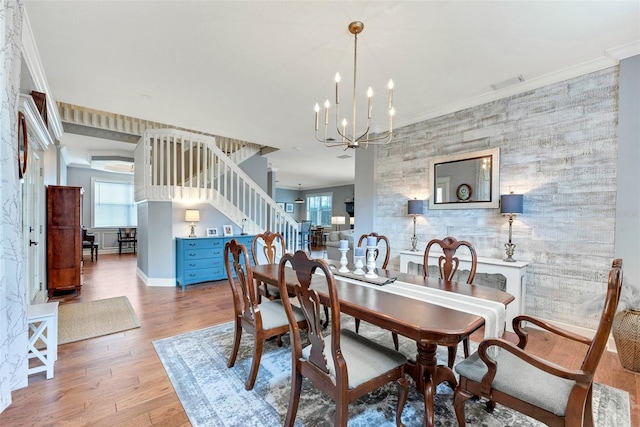 dining room with ornamental molding, a chandelier, and light hardwood / wood-style flooring