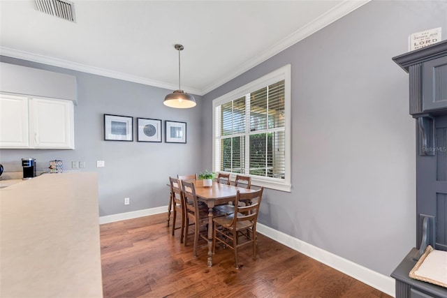 dining space with crown molding and dark wood-type flooring