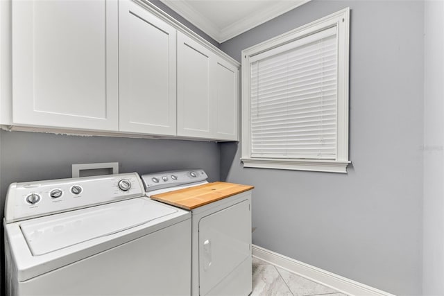 washroom with ornamental molding, cabinets, and washing machine and clothes dryer