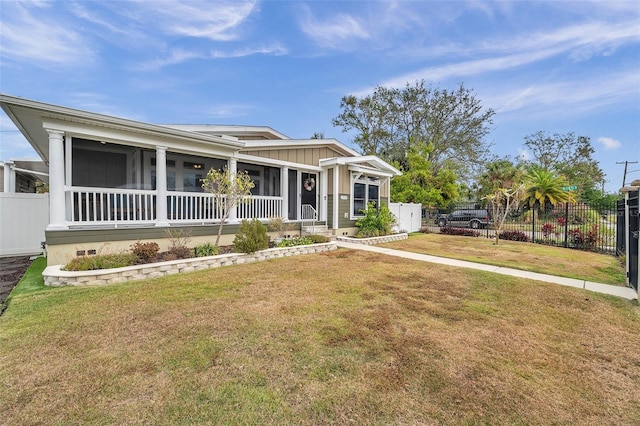 view of front facade with a front lawn and a sunroom