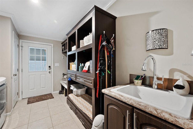 mudroom with washing machine and clothes dryer, light tile patterned floors, sink, and ornamental molding