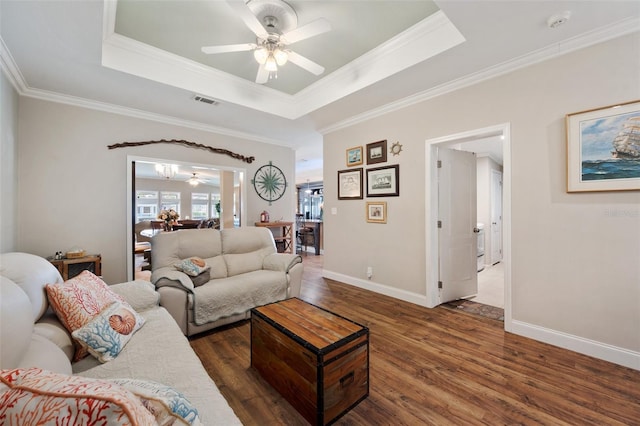 living room with ceiling fan, dark hardwood / wood-style floors, ornamental molding, and a raised ceiling