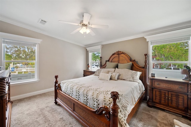 bedroom featuring ceiling fan, ornamental molding, carpet floors, and multiple windows