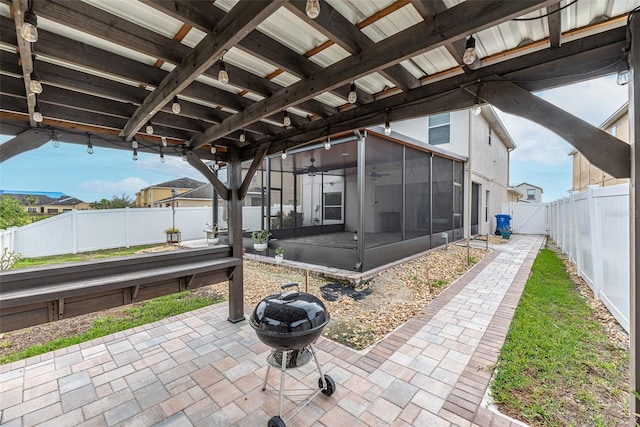 view of patio / terrace featuring ceiling fan, an outdoor fire pit, and a sunroom