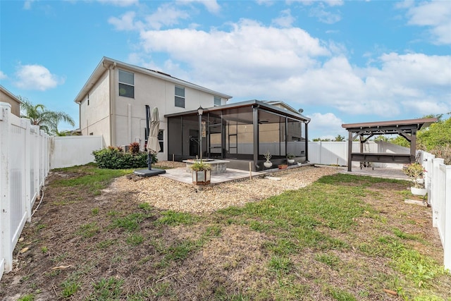 rear view of property with a patio, a gazebo, a yard, and a sunroom