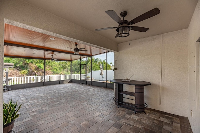 unfurnished sunroom with ceiling fan