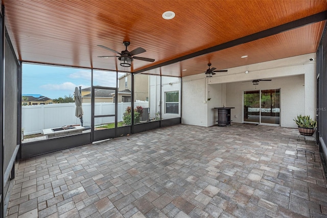 unfurnished sunroom featuring ceiling fan and wooden ceiling