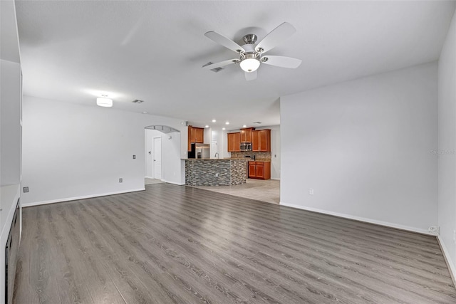 unfurnished living room with light hardwood / wood-style floors and ceiling fan