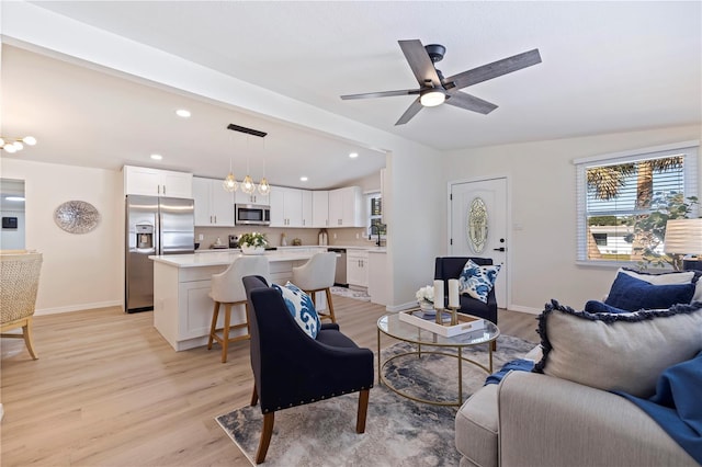 living room with light wood-style flooring, baseboards, and recessed lighting