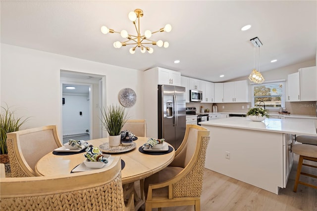 dining room with light wood finished floors, a chandelier, and recessed lighting