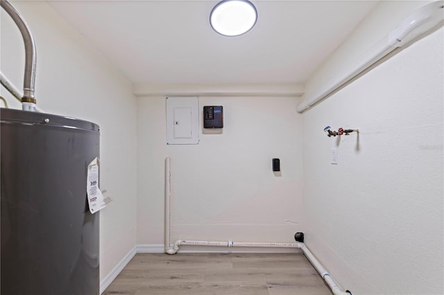 laundry area with laundry area, electric panel, baseboards, light wood-type flooring, and water heater