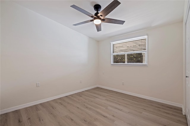 spare room featuring ceiling fan, light wood-style floors, and baseboards