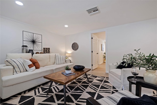 living room with crown molding, light wood-style floors, visible vents, and recessed lighting