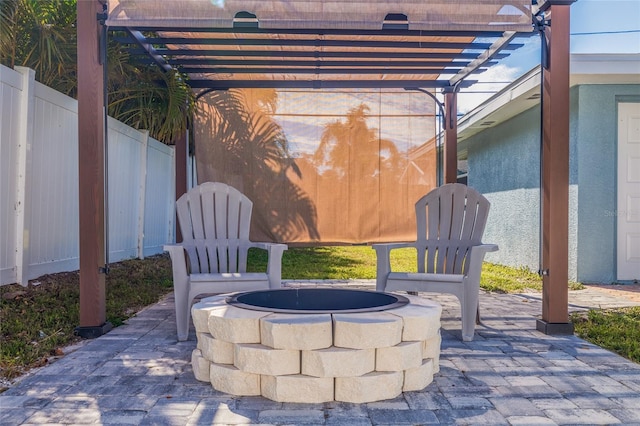 view of patio with fence, a fire pit, and a pergola