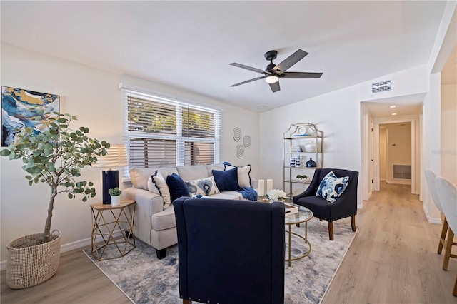 living area with visible vents, light wood-style floors, and ceiling fan