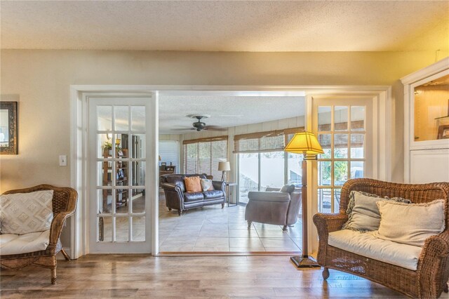 sitting room with hardwood / wood-style flooring, a textured ceiling, and ceiling fan