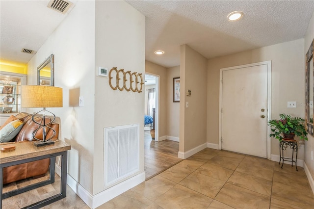 entryway featuring a textured ceiling and light tile patterned floors