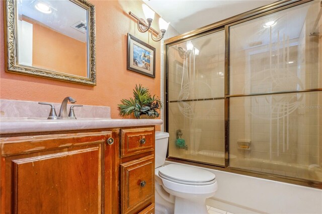 full bathroom featuring toilet, tile patterned flooring, vanity, and shower / bath combination with glass door