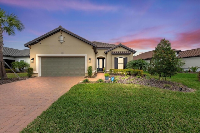 mediterranean / spanish-style house featuring a yard and a garage