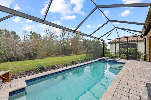 view of swimming pool with an in ground hot tub, a yard, a patio area, and glass enclosure