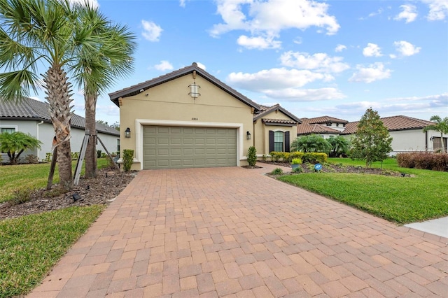 mediterranean / spanish house featuring a garage and a front lawn