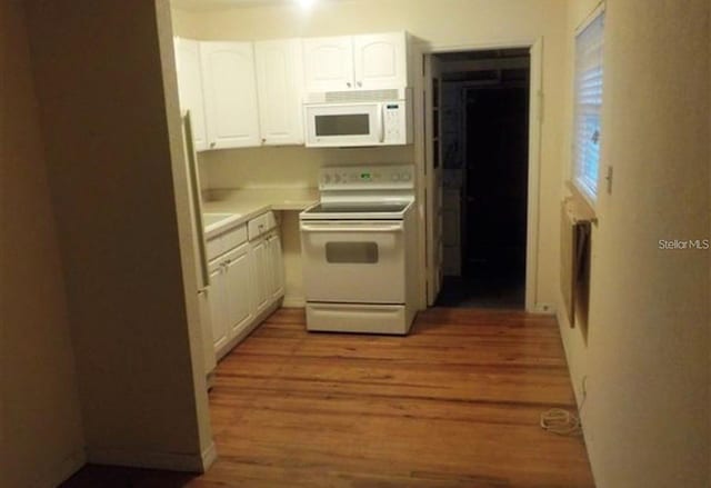 kitchen featuring light wood-type flooring, white cabinets, and white appliances