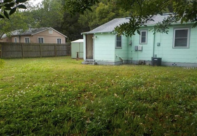 view of yard with central AC and a shed